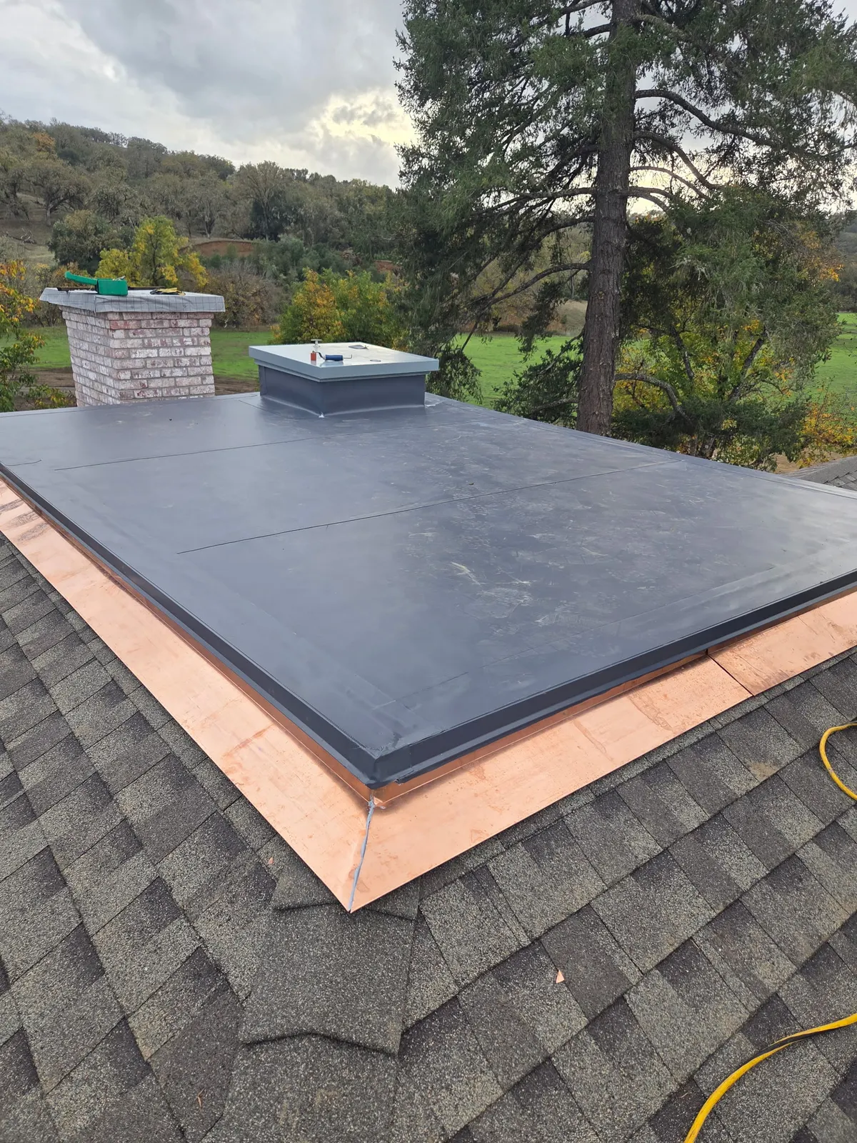 Black standing-seam metal roof installed on a garage during new construction
