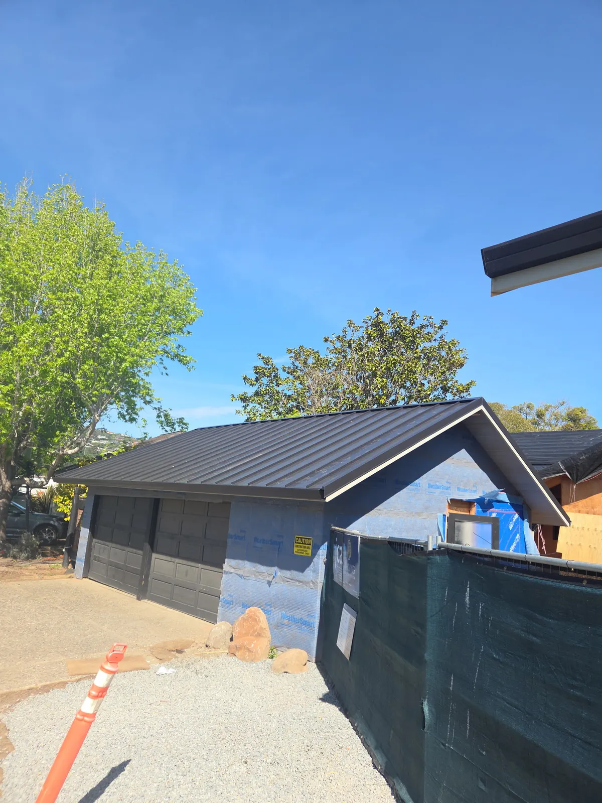 Black standing-seam metal roof on a residential outbuilding