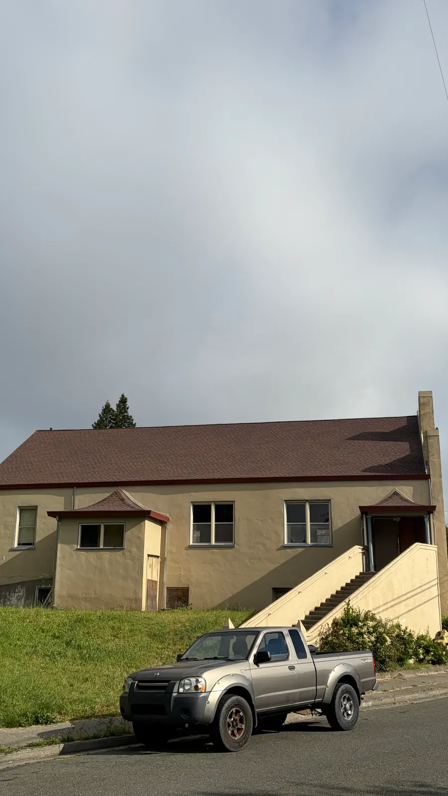 Brown shingle roof replacement on a hillside multifamily building