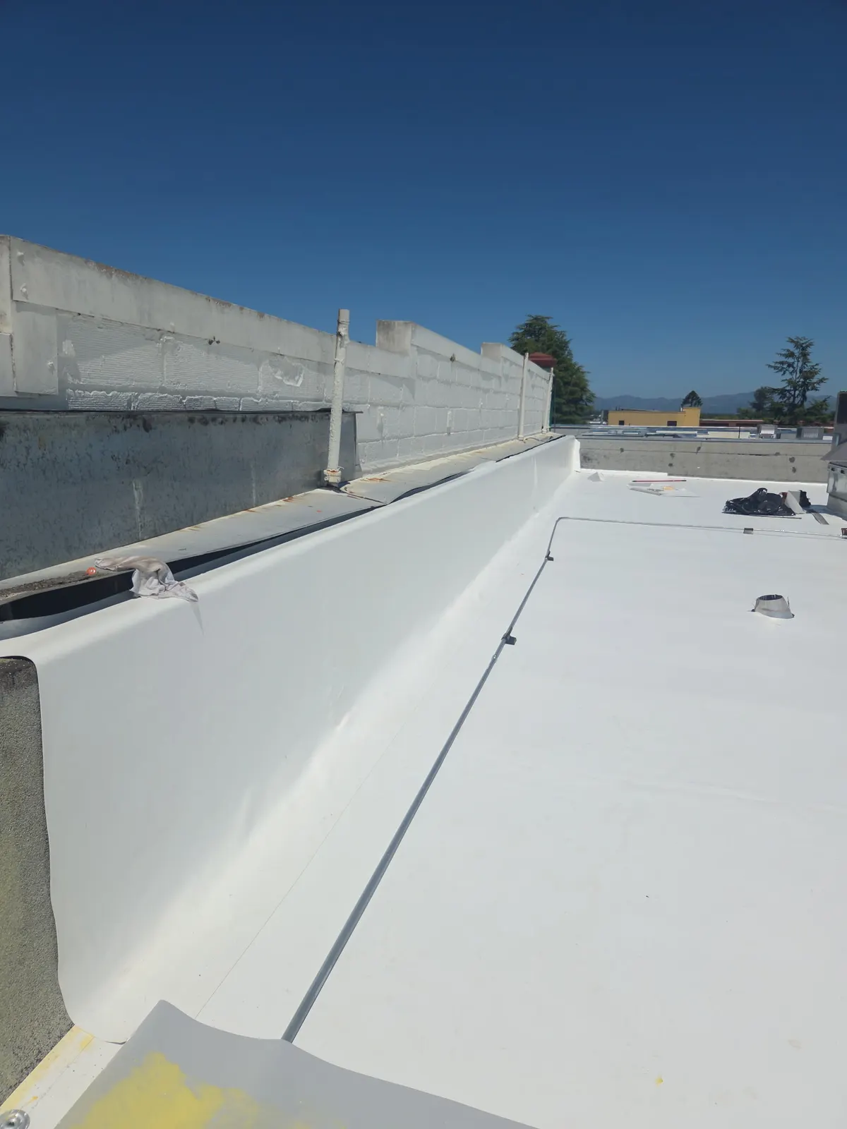 Parapet wall flashing detail on a white TPO commercial roof system