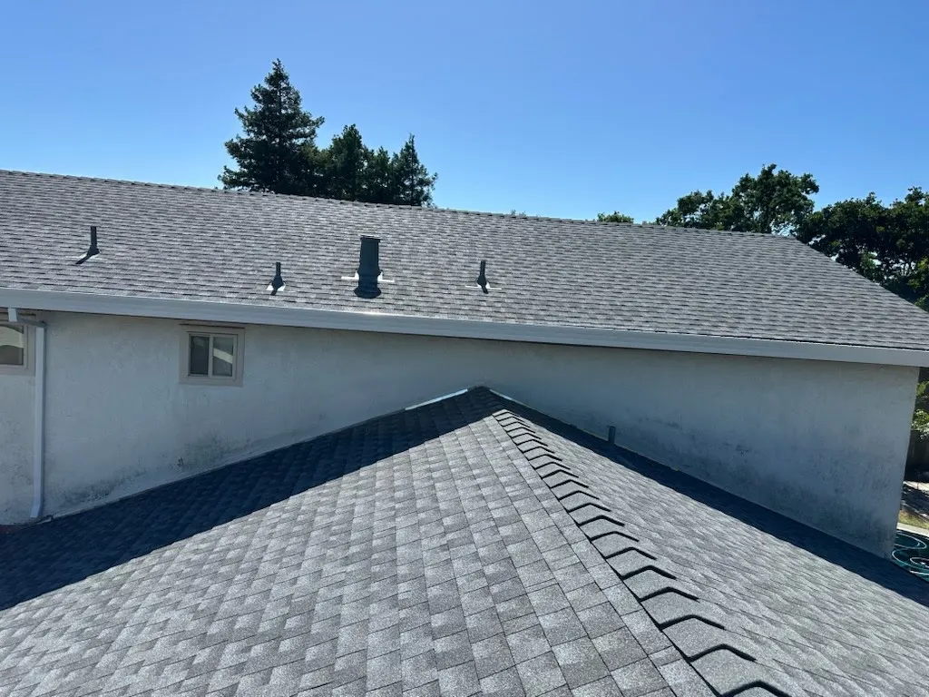 Completed gray shingle roof on a stucco home