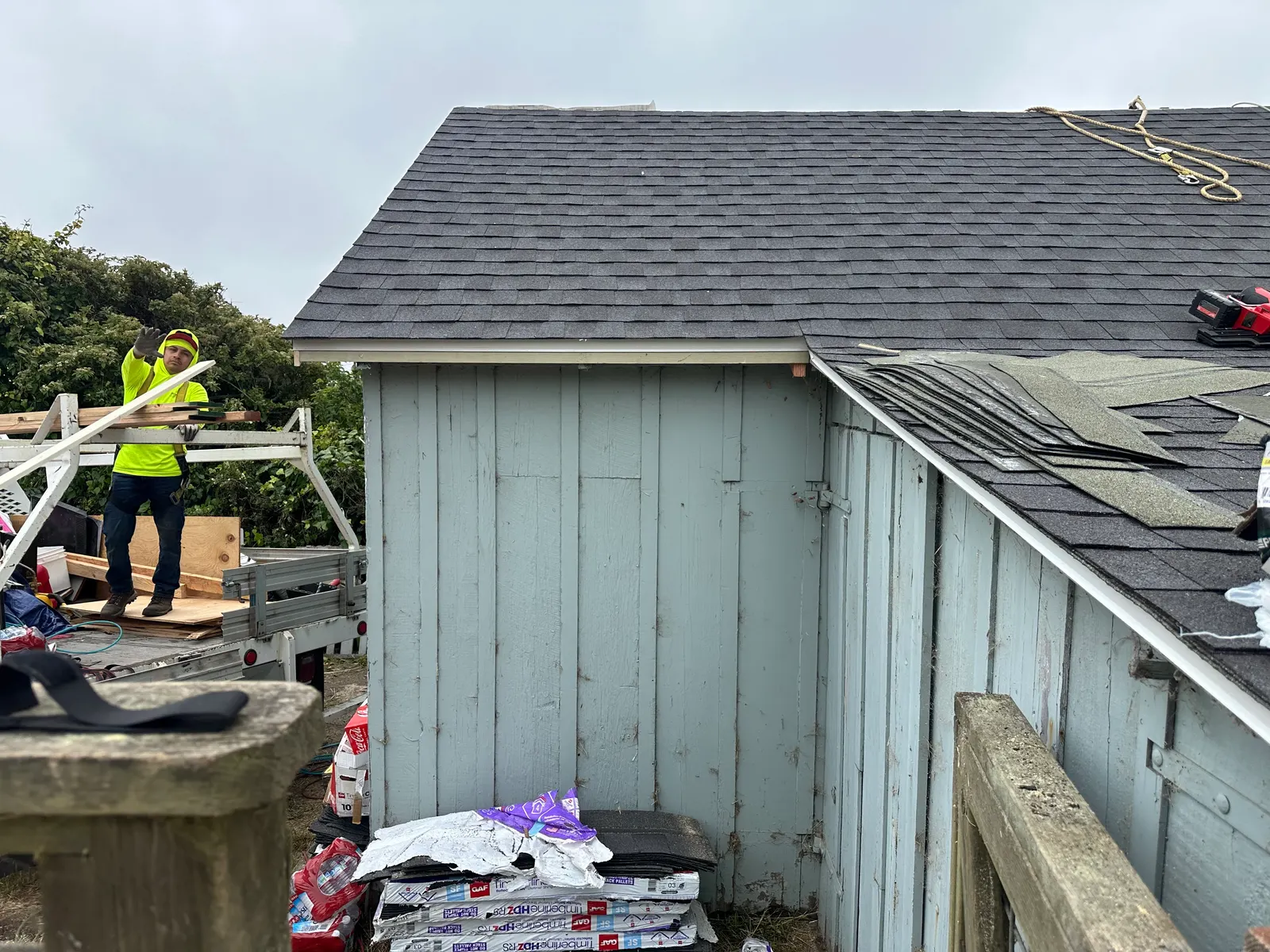 Crew loading shingles from a trailer at a coastal re-roof project