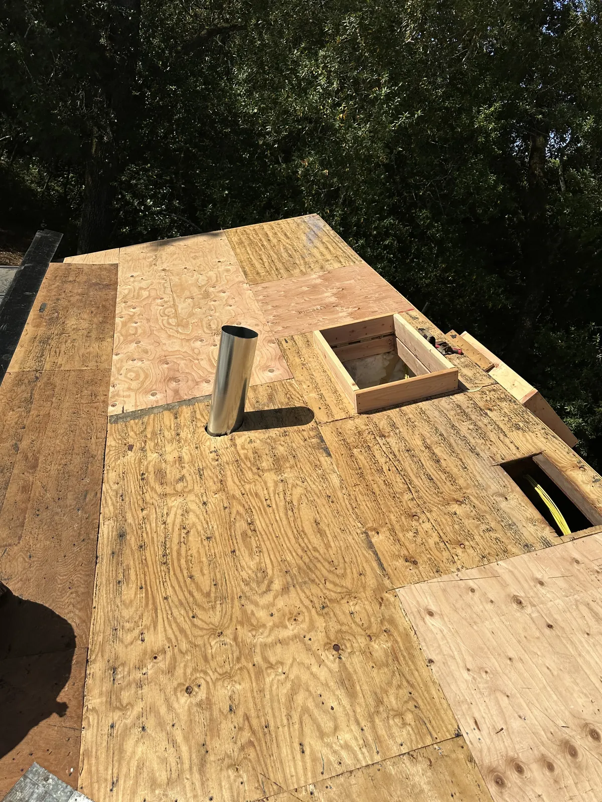 New plywood roof decking with a framed skylight curb and vent penetration during a Sonoma re-roof