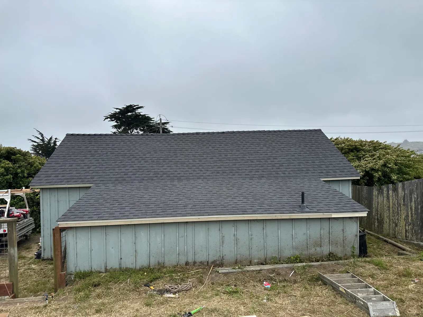 New composition shingle roof on a coastal outbuilding in the fog