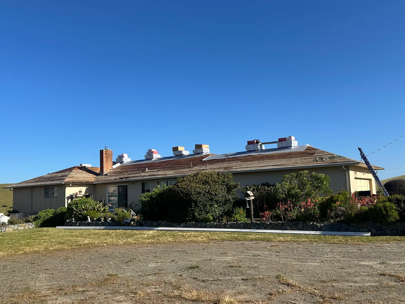 Roof replacement in progress across a sprawling ranch home