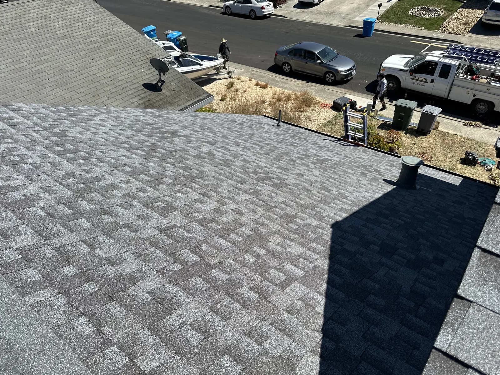Finished shingle roof slope above a clean Rohnert Park job site with the Sutter Roofing truck at the curb