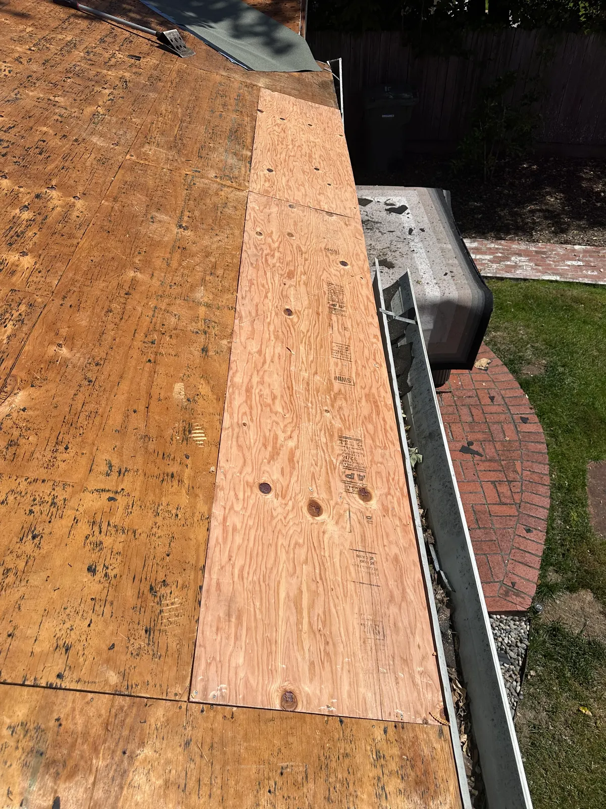 New plywood roof deck sheathing installed at the eave during tear-off