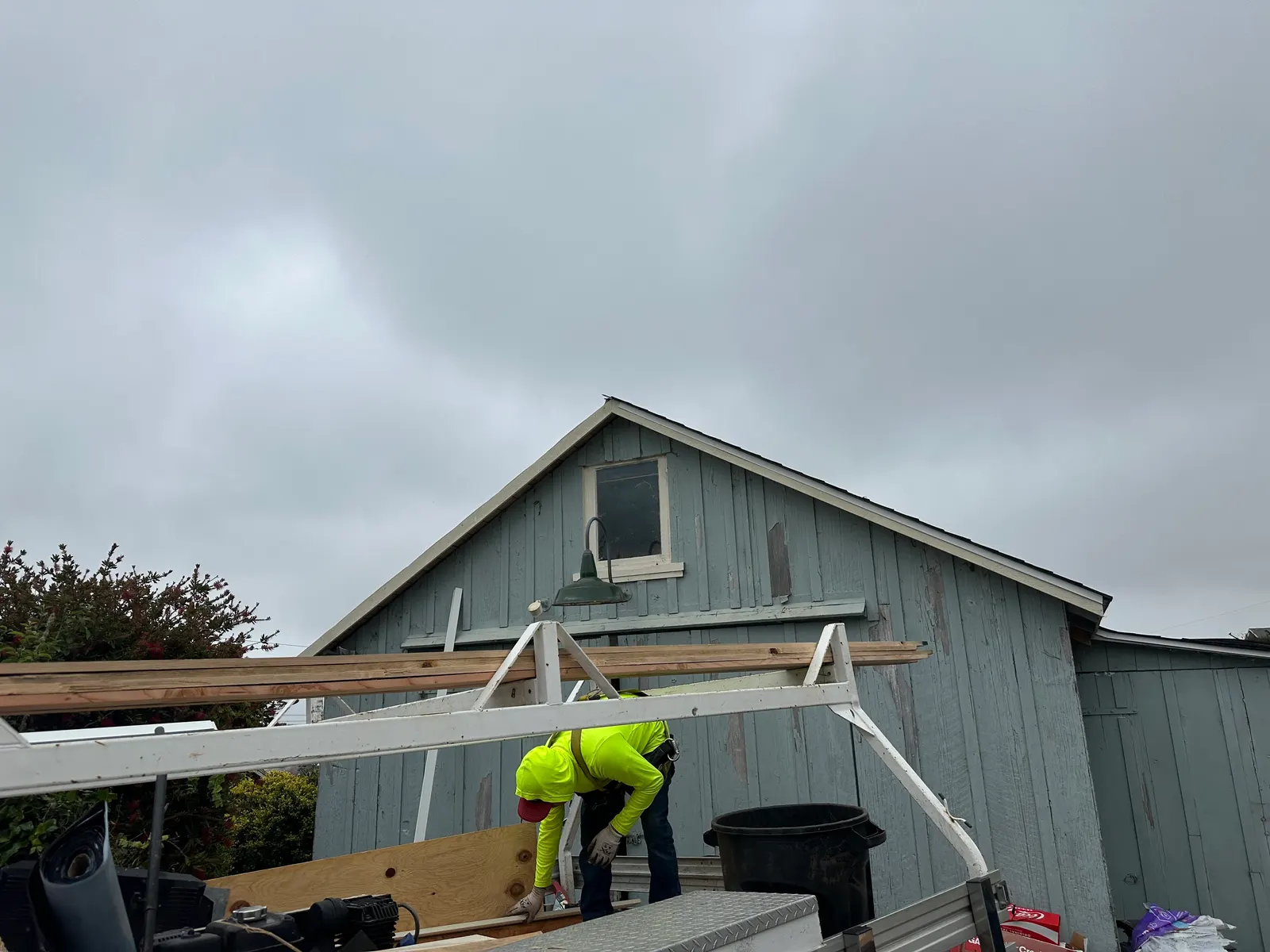 Roofing crew member prepping materials at ground level