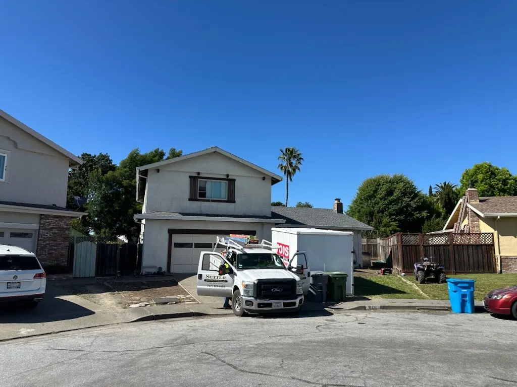 Roofing work truck staged in a residential driveway on job day